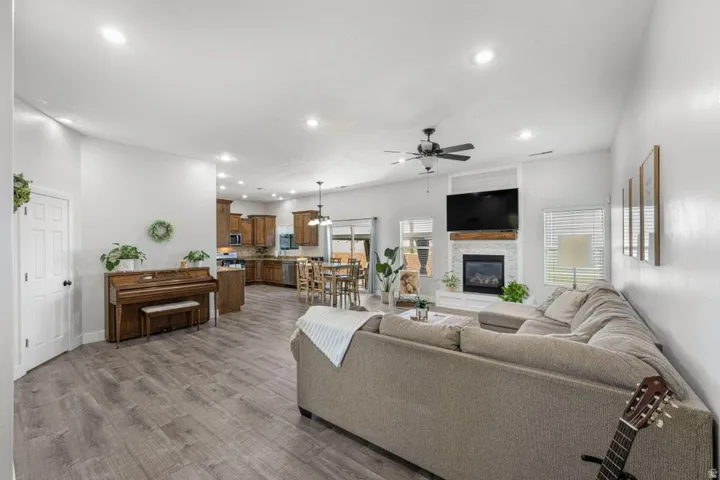 Open-concept living space featuring wood-finish flooring, recessed lighting, and a ceiling fan