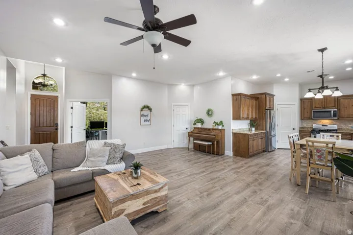 Open-concept living space featuring wood-finish flooring, recessed lighting, and a ceiling fan