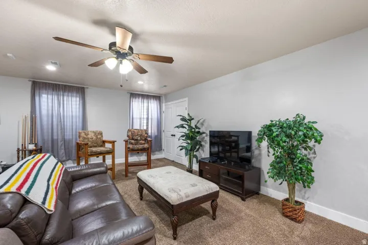 Carpeted flooring, two windows with blinds, recessed lighting, and a ceiling fan with integrated light fixture