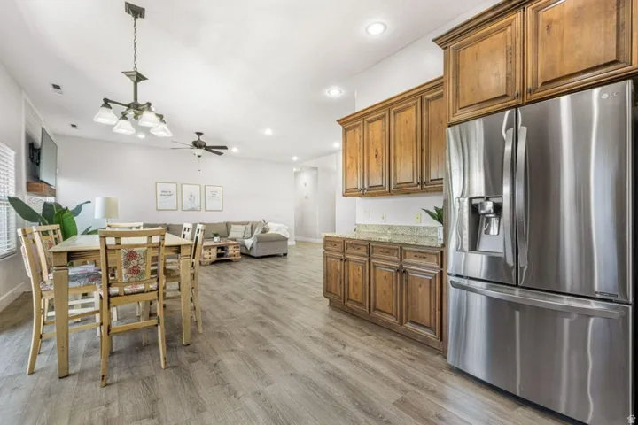 Open-concept living space with wood-finish flooring, recessed lighting, and a ceiling fan