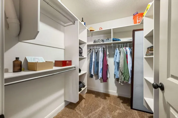 Custom closet system featuring extensive shelving, multiple hanging rods, and an integrated full-length mirror