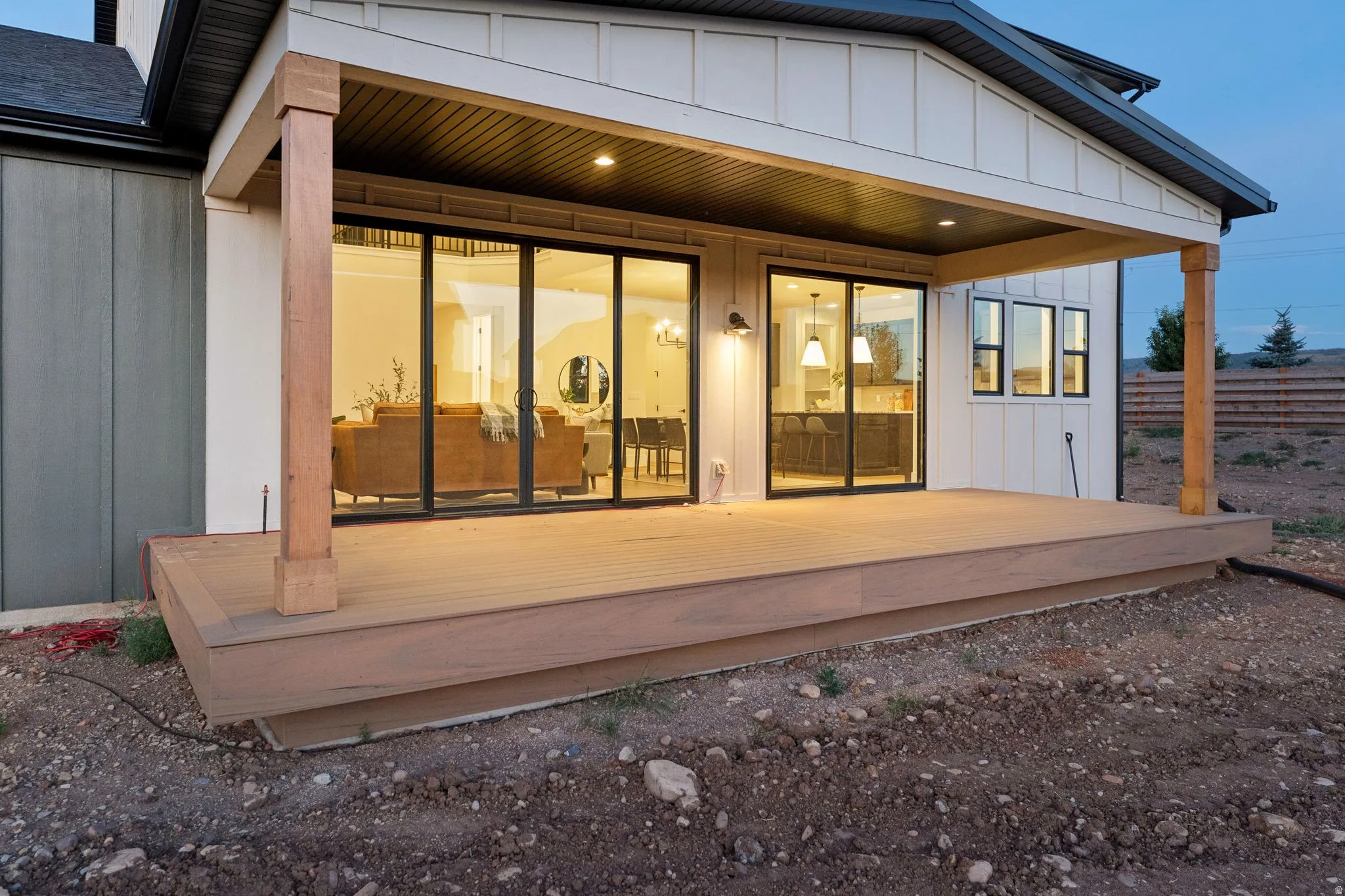 Covered patio with recessed lighting, wood-finish decking, and sliding glass doors