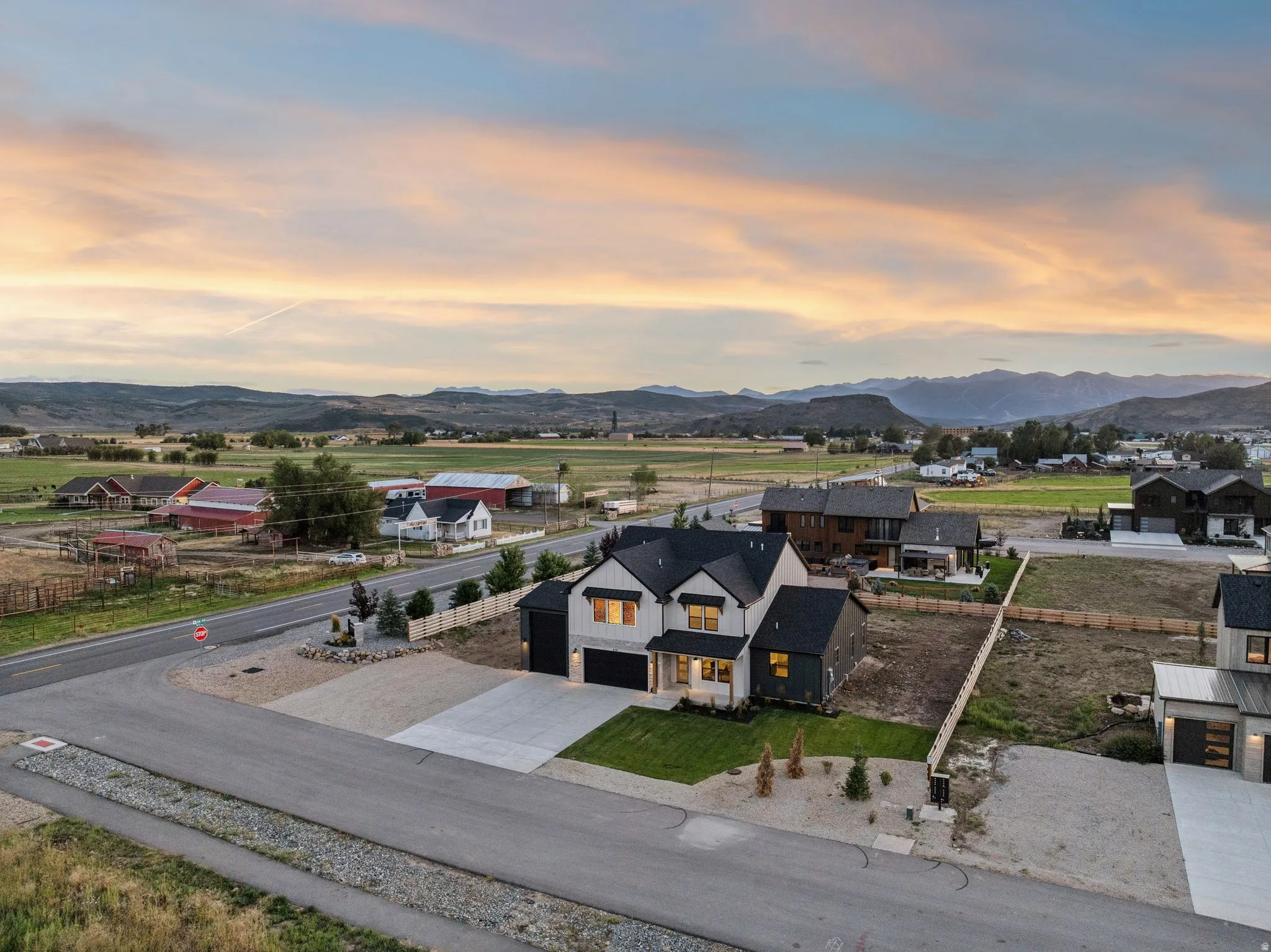 Modern architectural design featuring a two-story structure with a dark roof and contrasting light and dark siding