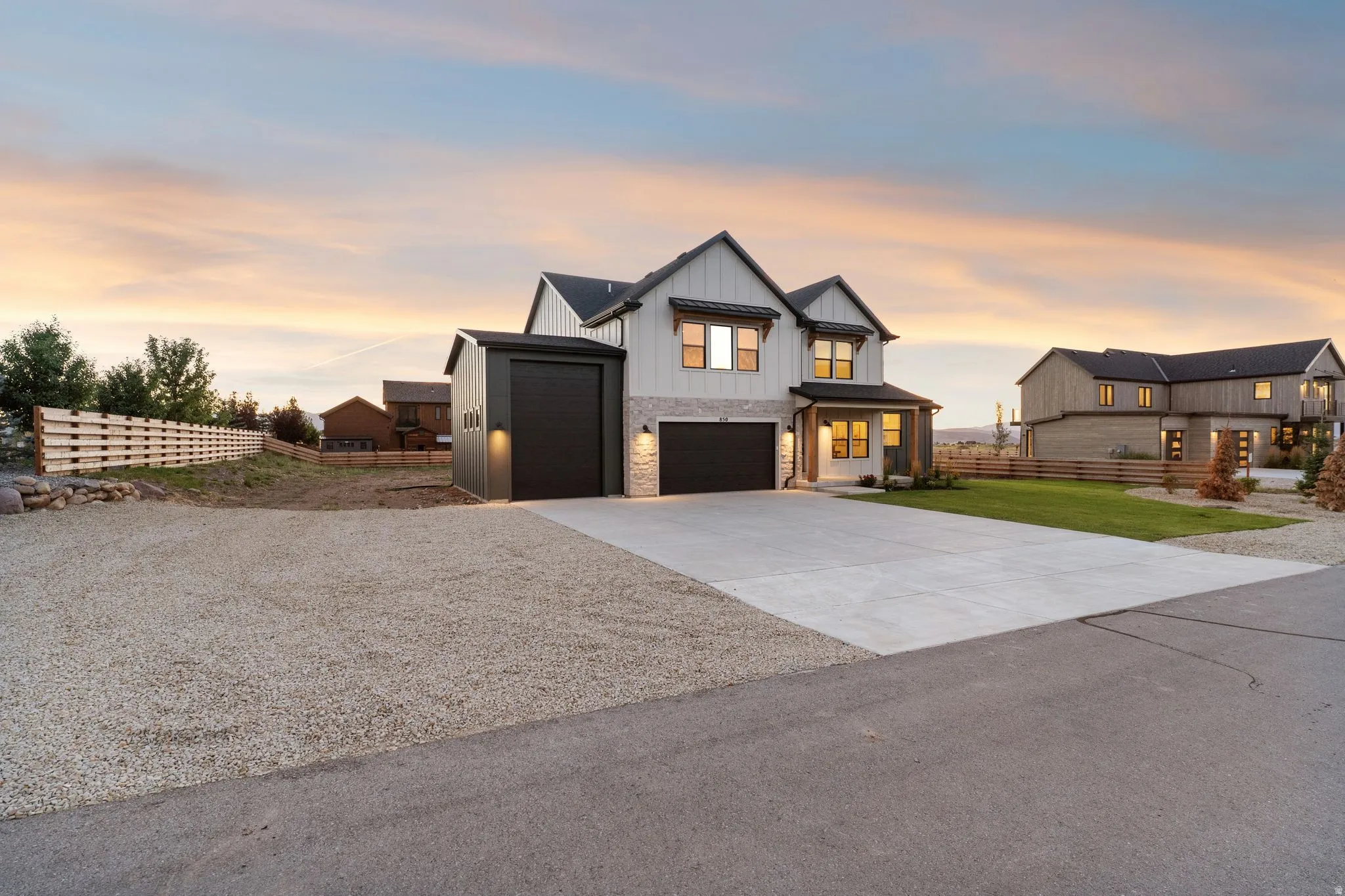 Contemporary two-story residence featuring a two-car garage, an additional single-car garage, and a concrete driveway
