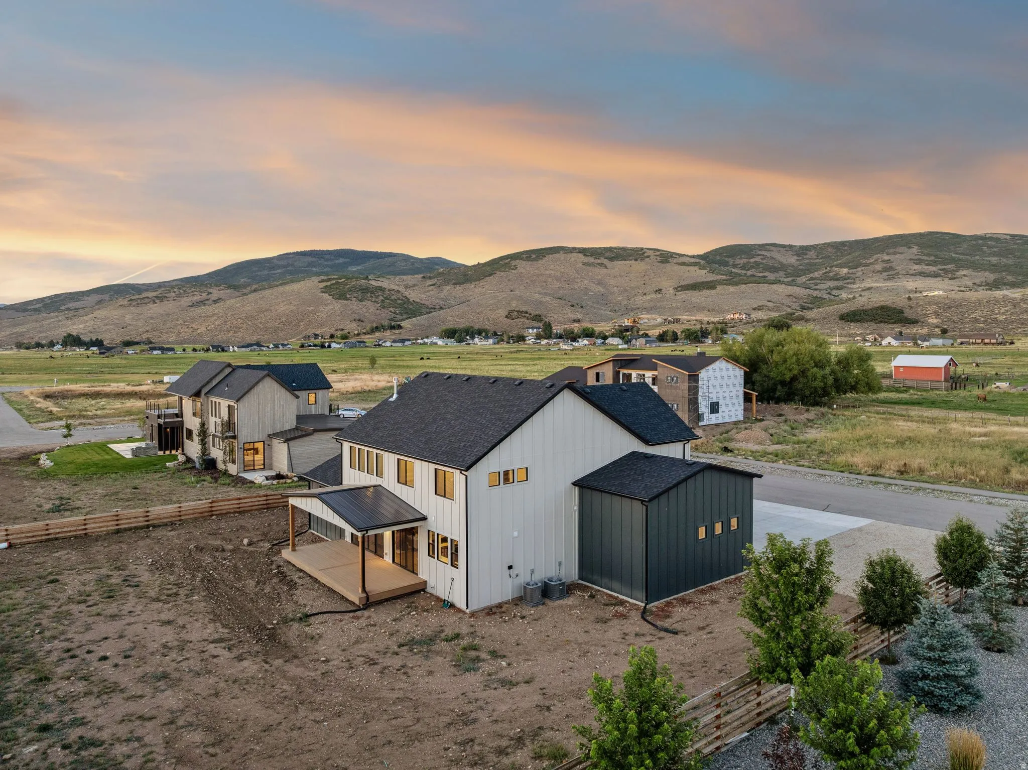Modern farmhouse-style residence with dark roof and light vertical siding