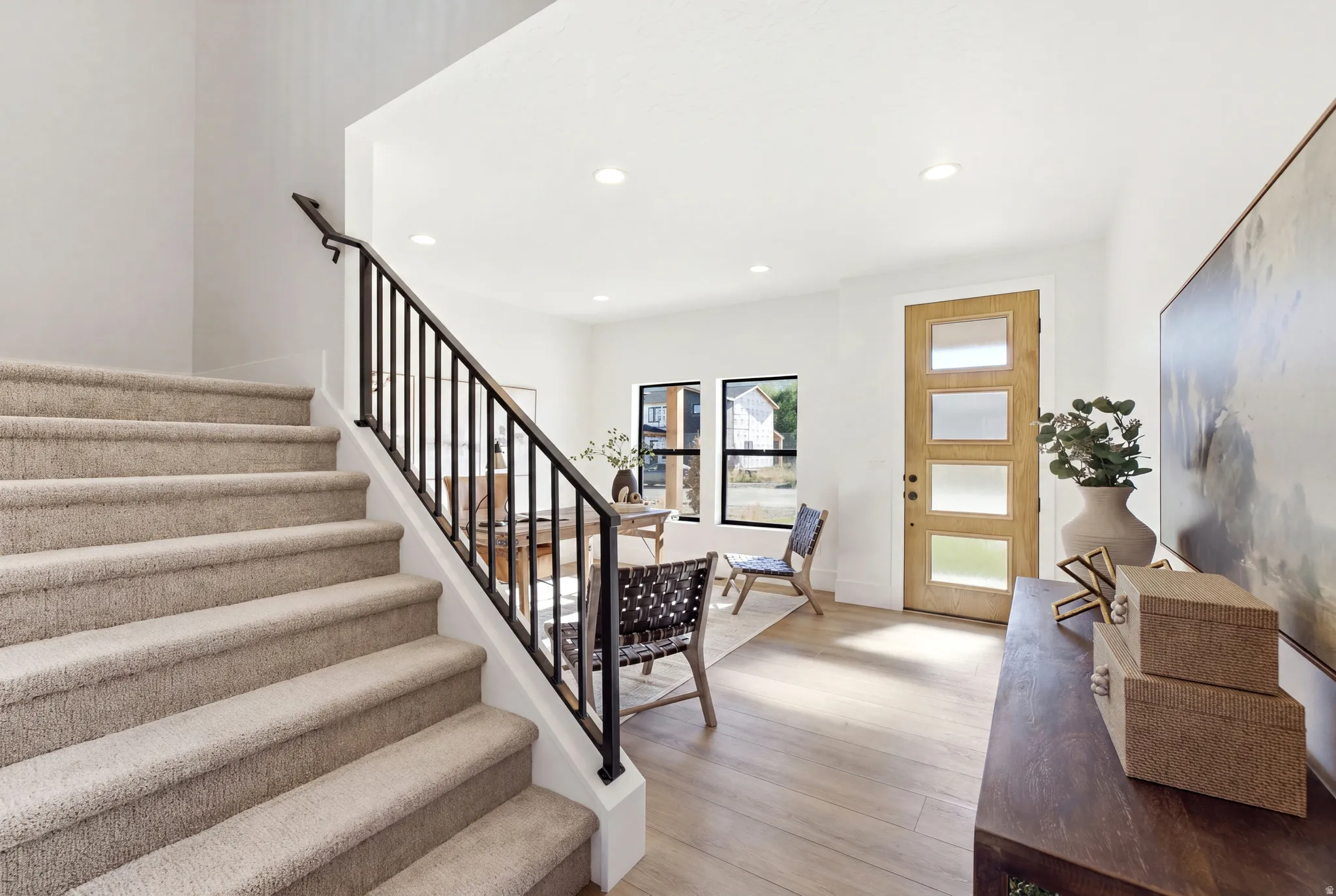 Hardwood-finish flooring, recessed lighting, and a modern entry door with frosted glass panels