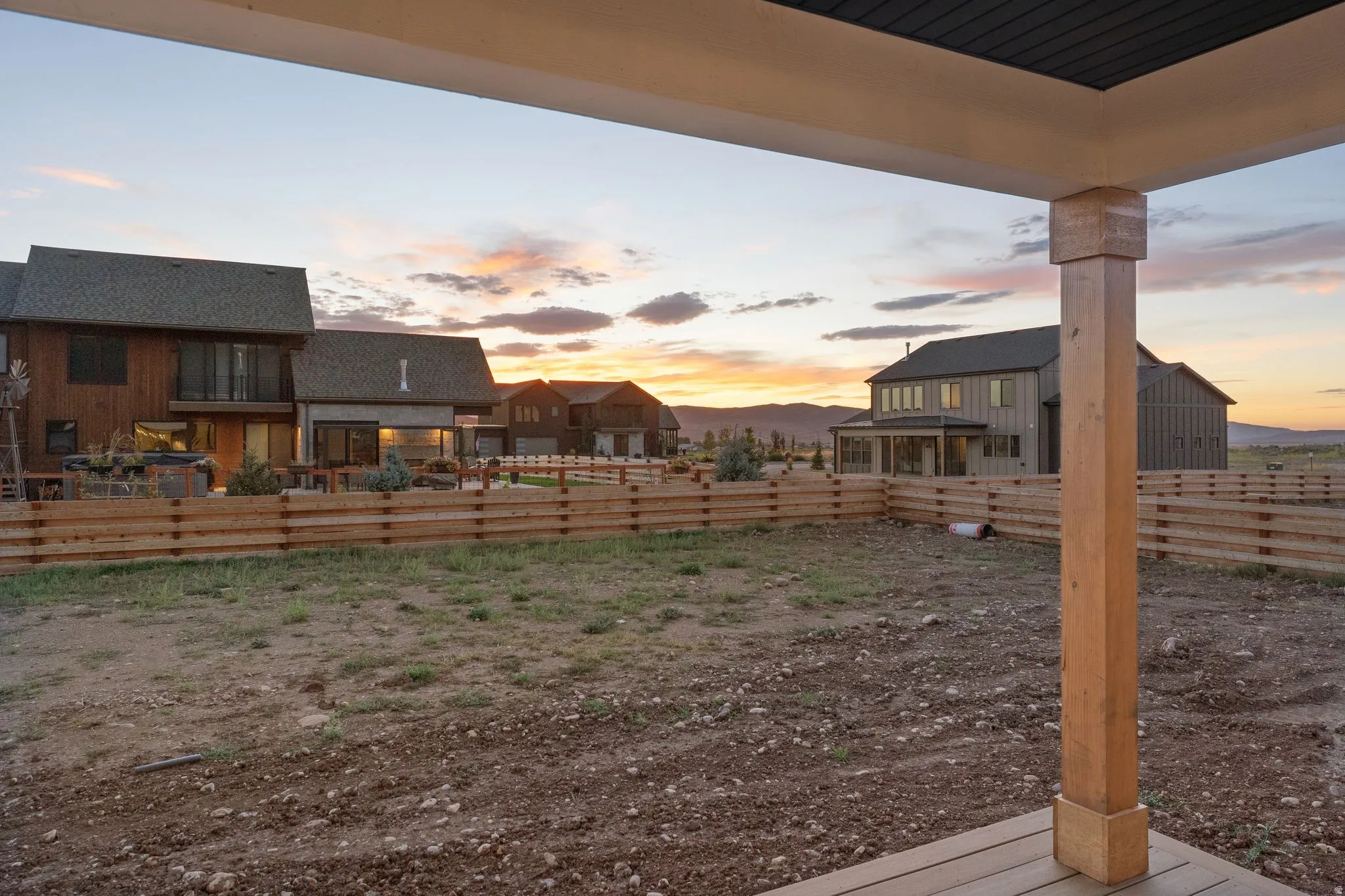 Expansive outdoor area with a durable wood-finish deck, sturdy wood support post, and a slatted wood fence