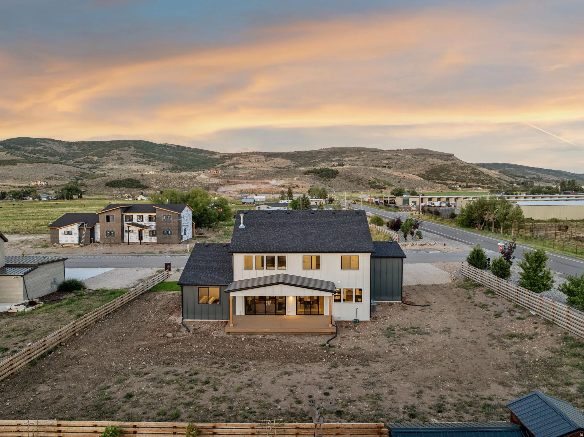 Modern two-story residence featuring a dark shingle roof and a covered rear deck