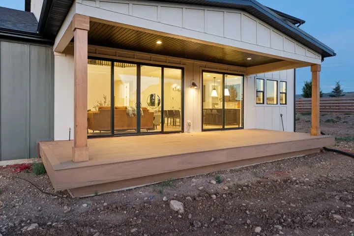 Covered patio with recessed lighting, wood-finish decking, and sliding glass doors