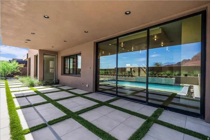 Expansive outdoor patio with concrete pavers and artificial turf accents