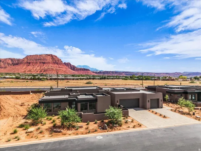 Contemporary exterior with a flat roofline, integrated garage doors, and a paved driveway