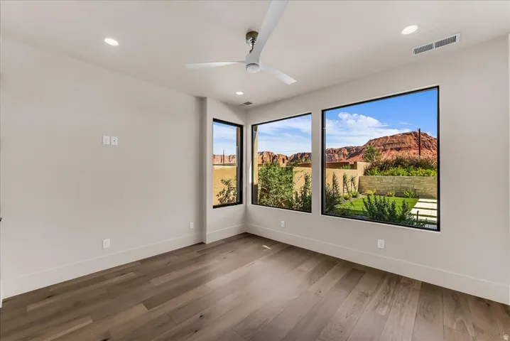 Wood-finish flooring, recessed lighting, and a contemporary ceiling fan