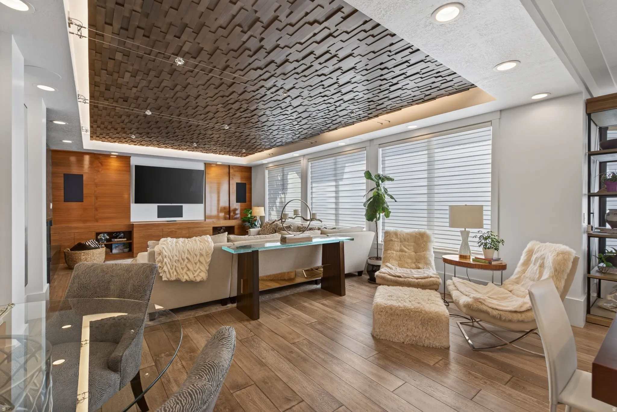 Recessed lighting, wood-finish flooring, accent ceiling treatment, wall-mounted display, and built-in shelving
