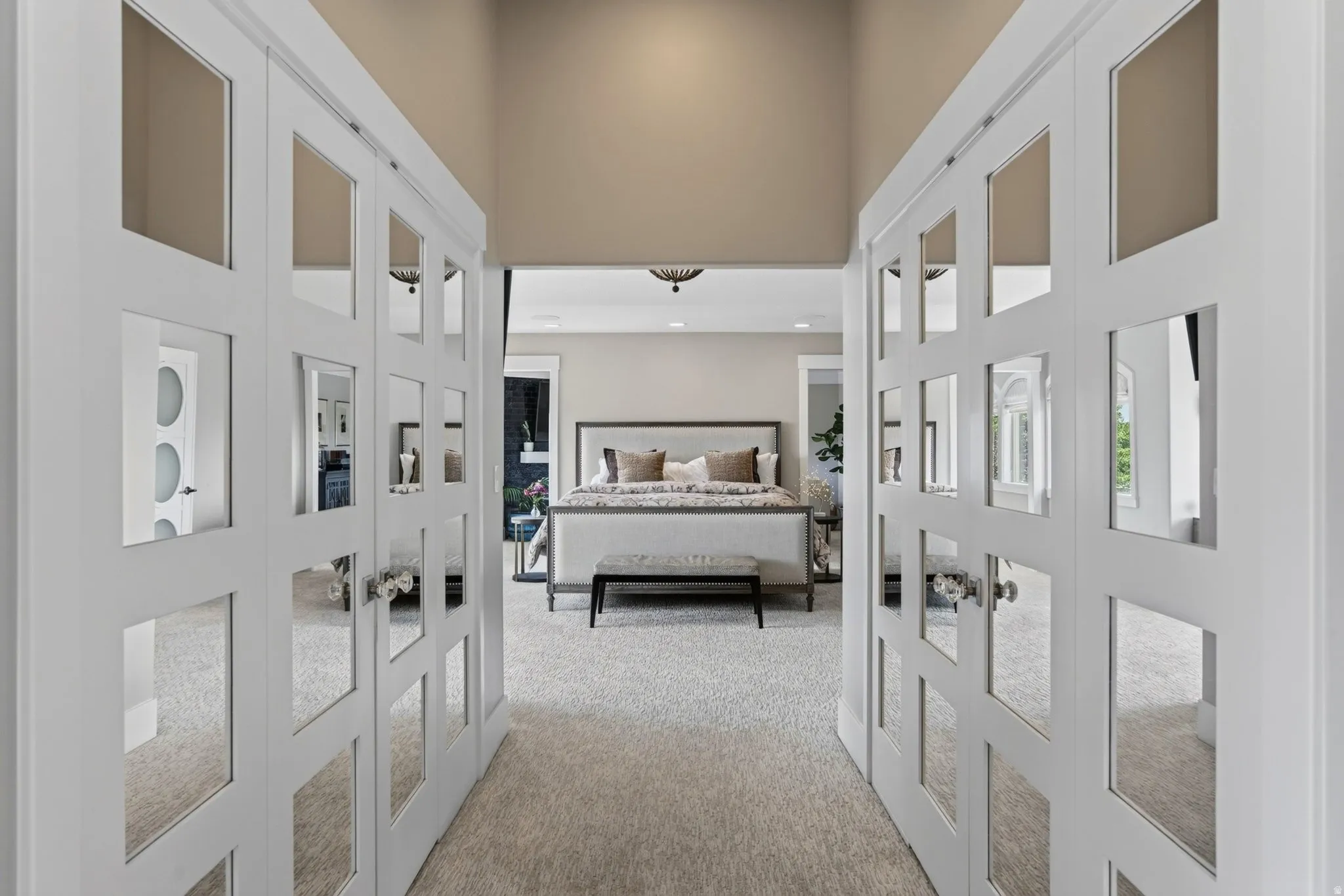 Open architectural doorway leading to a carpeted room featuring a high ceiling, and recessed lighting