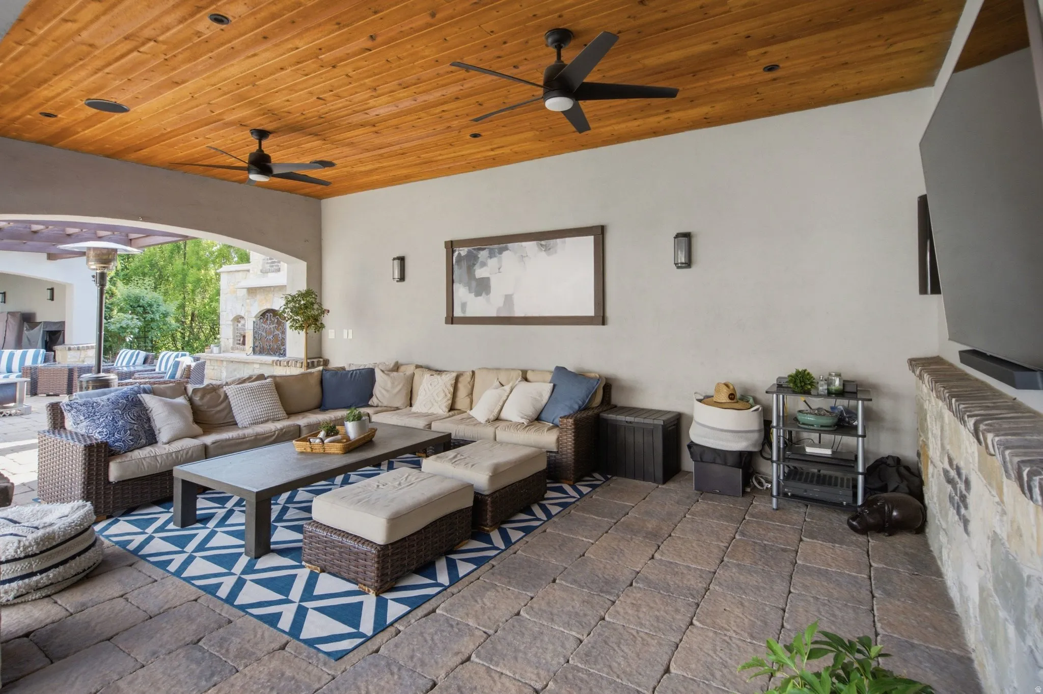 Covered patio with a wood-plank ceiling, recessed lighting, and ceiling fans