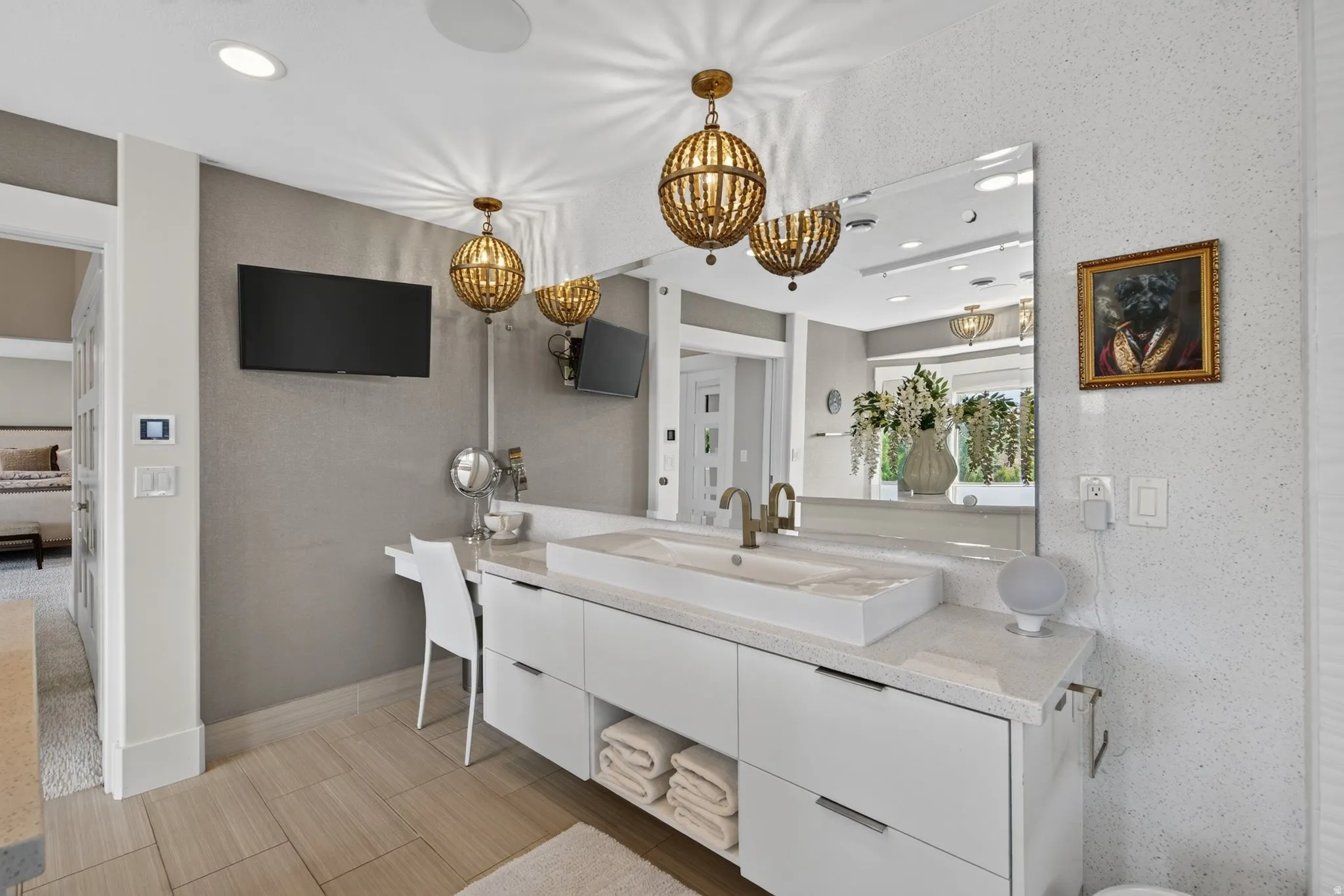 Double vanity with an integrated vessel sink, white cabinetry, a large frameless mirror, and two decorative pendant lights