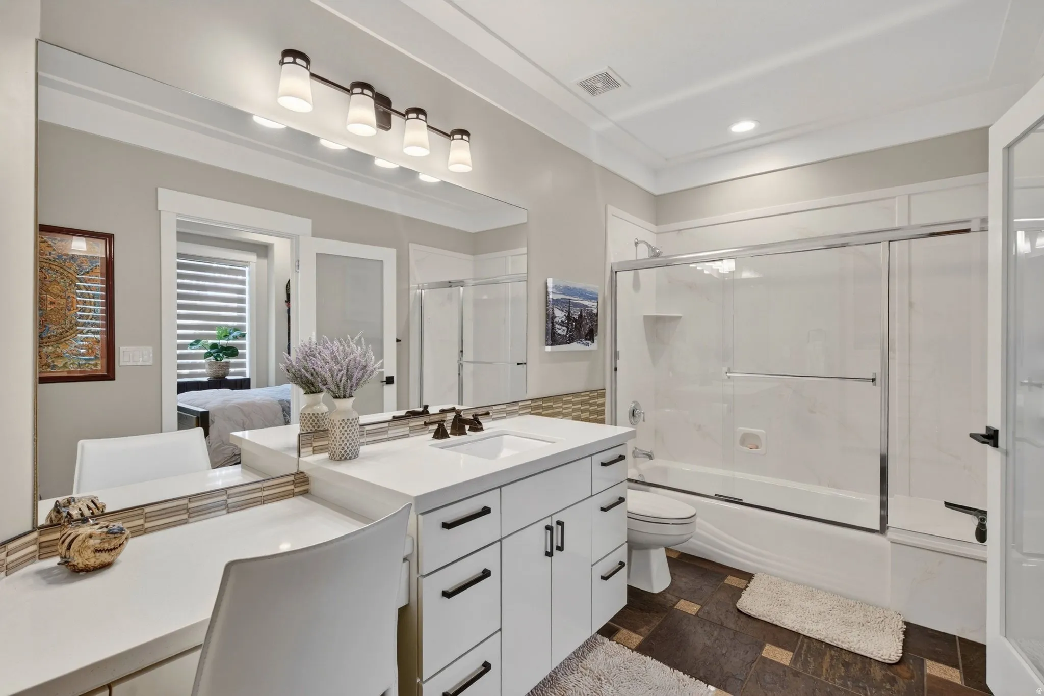 White vanity with integrated sink, black hardware, and quartz countertop