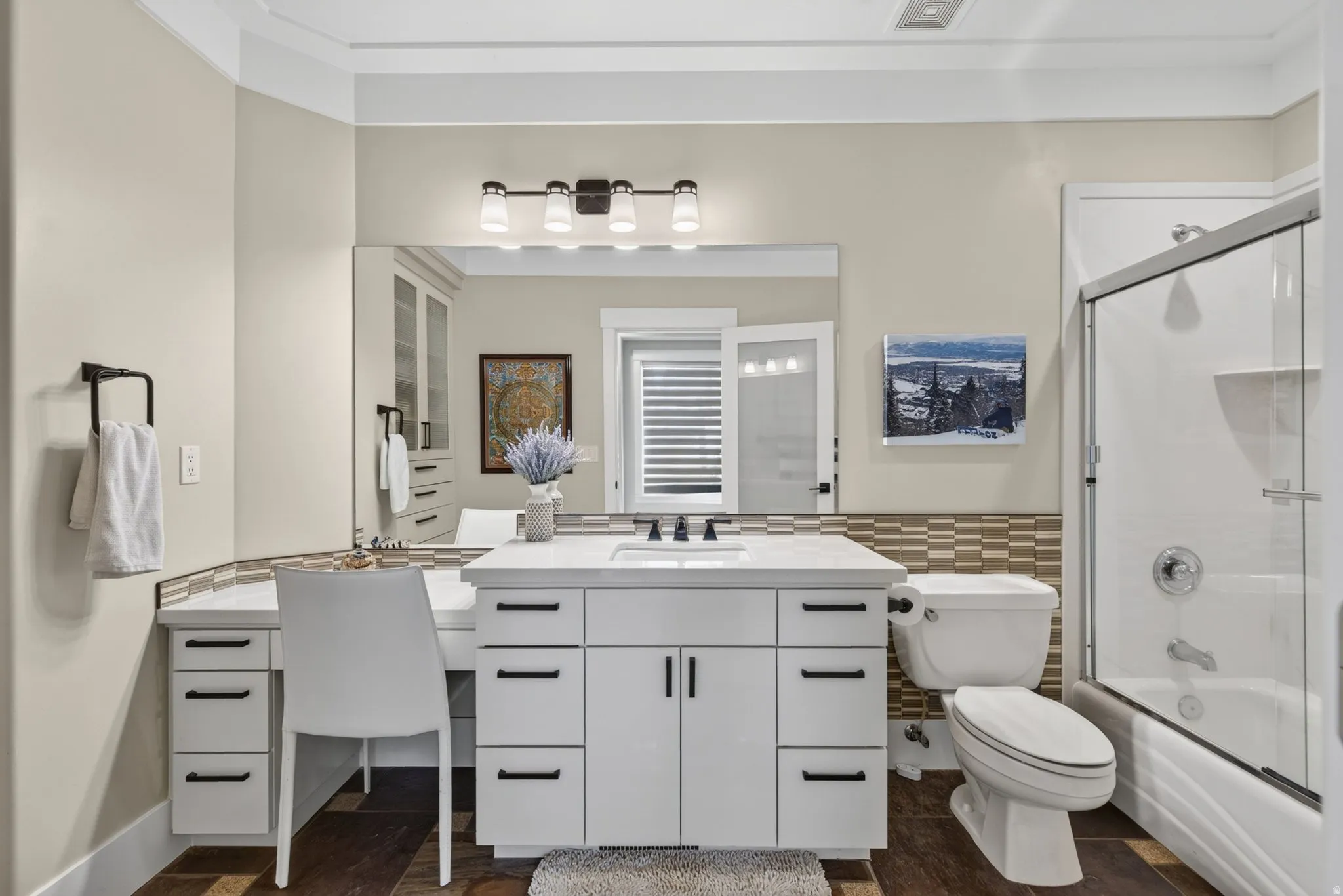White vanity with integrated sink, black fixtures, and a vanity lighting fixture