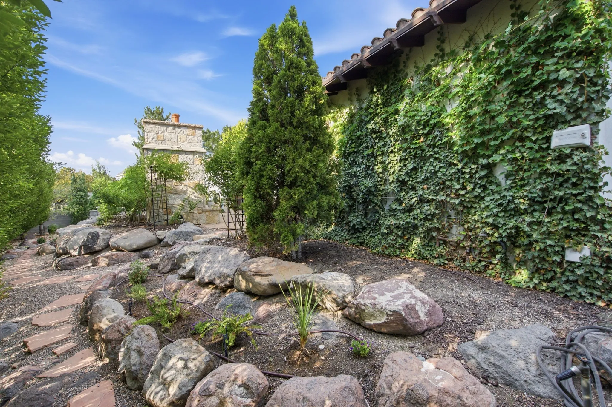 Stone pathway with natural rock landscaping and mature plantings