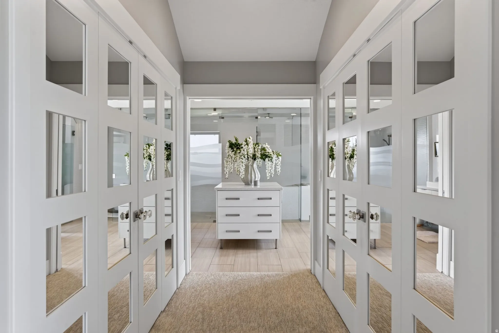 Mirrored sliding closet doors, neutral carpeting, and light wood-finish flooring