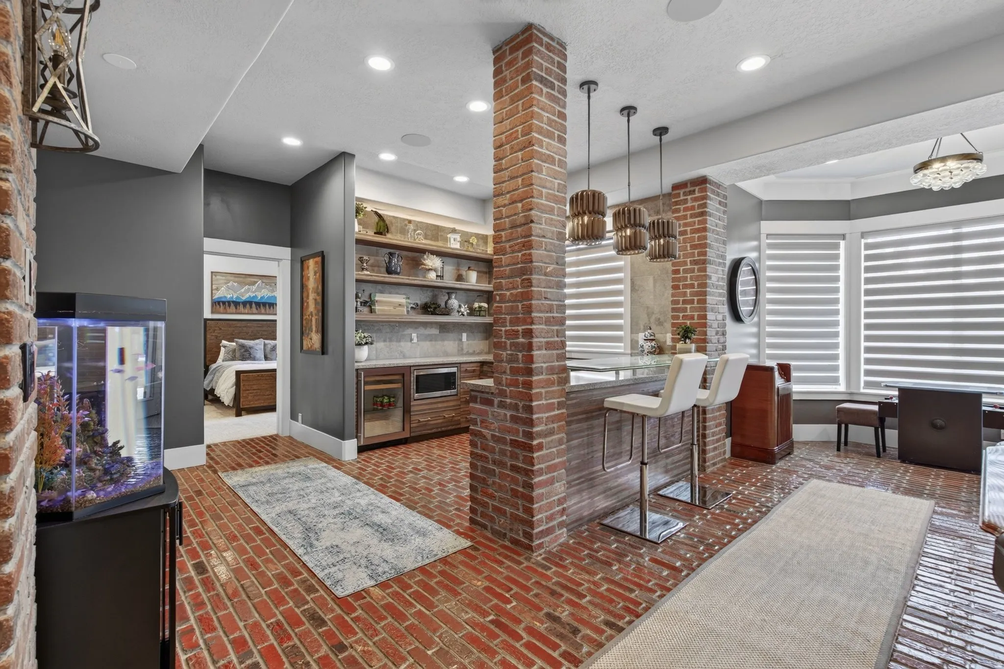 Exposed brick accents, brick flooring, built-in shelving, recessed lighting, and a bay window