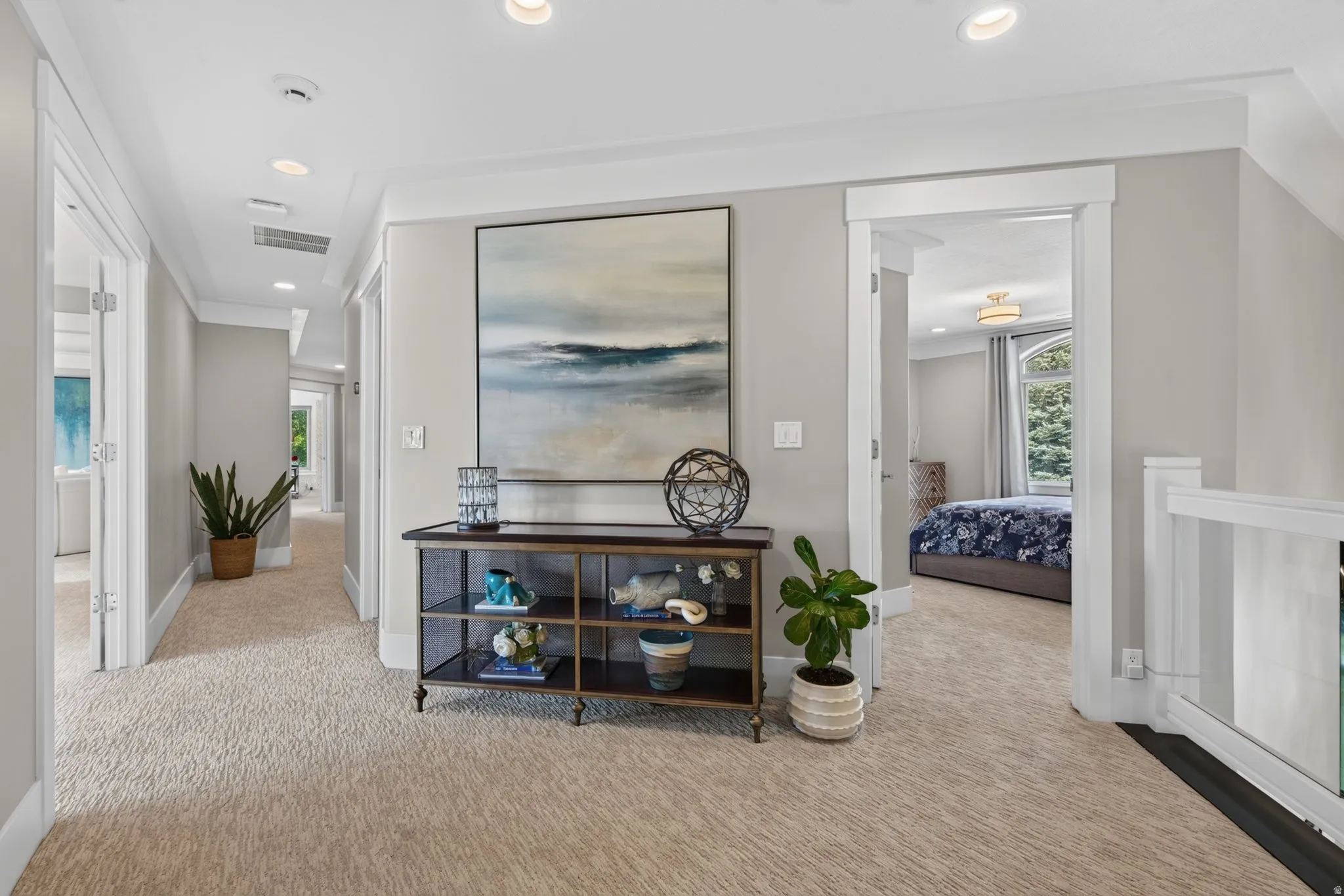 Carpeted hallway with recessed lighting and a built-in console table