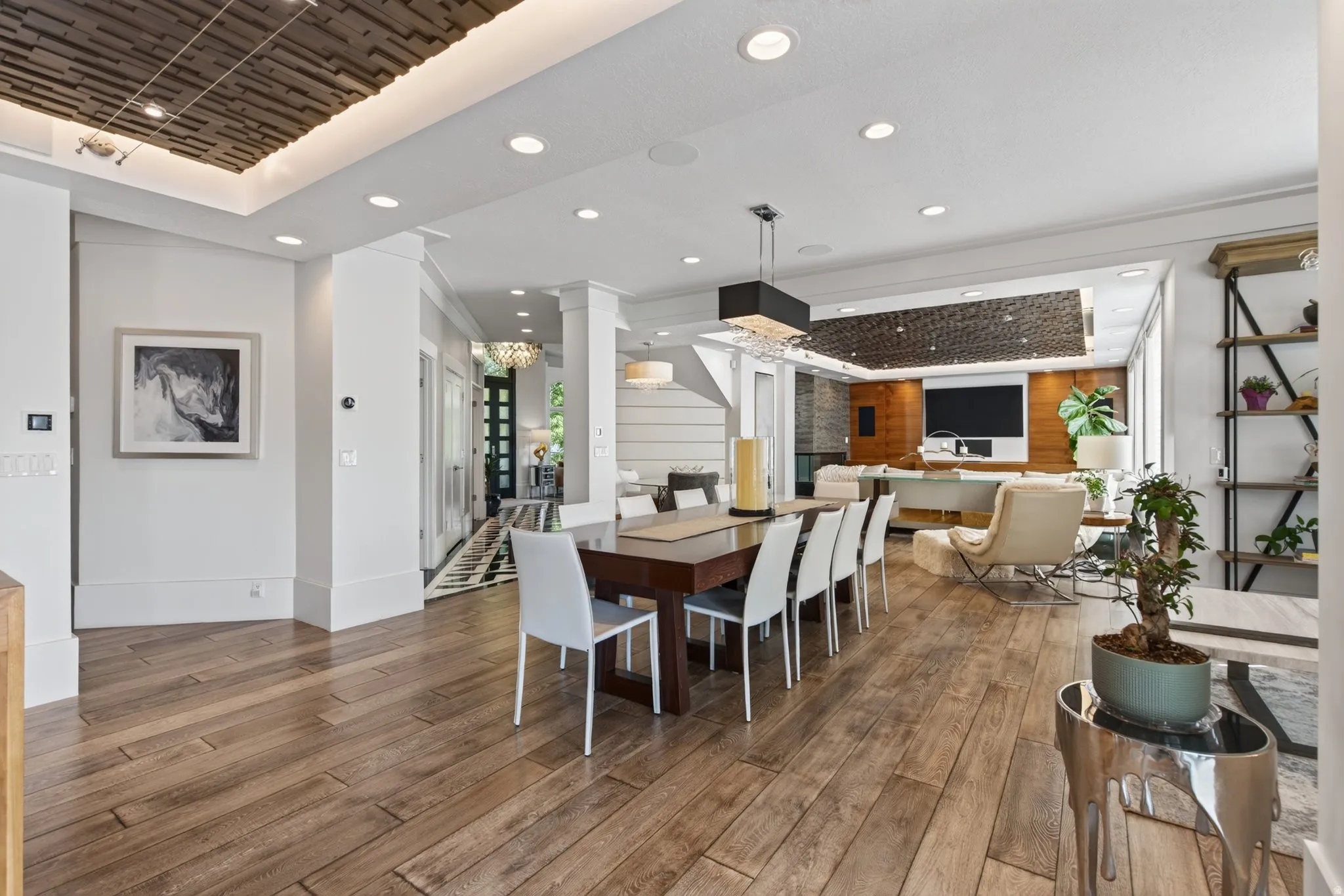 Open-concept living space with wood-finish flooring, recessed lighting, and a textured ceiling feature