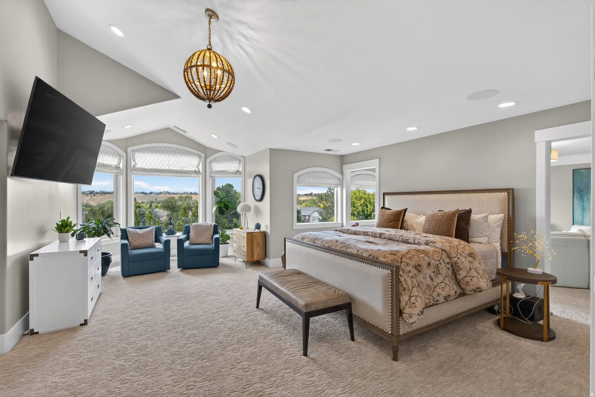 Vaulted ceiling with an ornate chandelier, recessed lighting, and a bay window