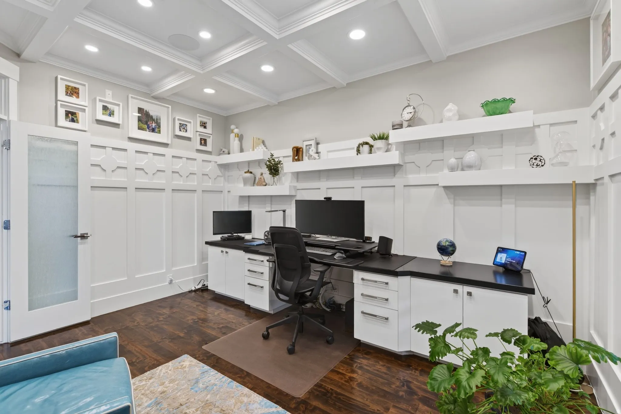 Coffered ceiling with recessed lighting, wood-finish flooring, white built-in cabinetry, dark countertops, and board and batten wall detailing