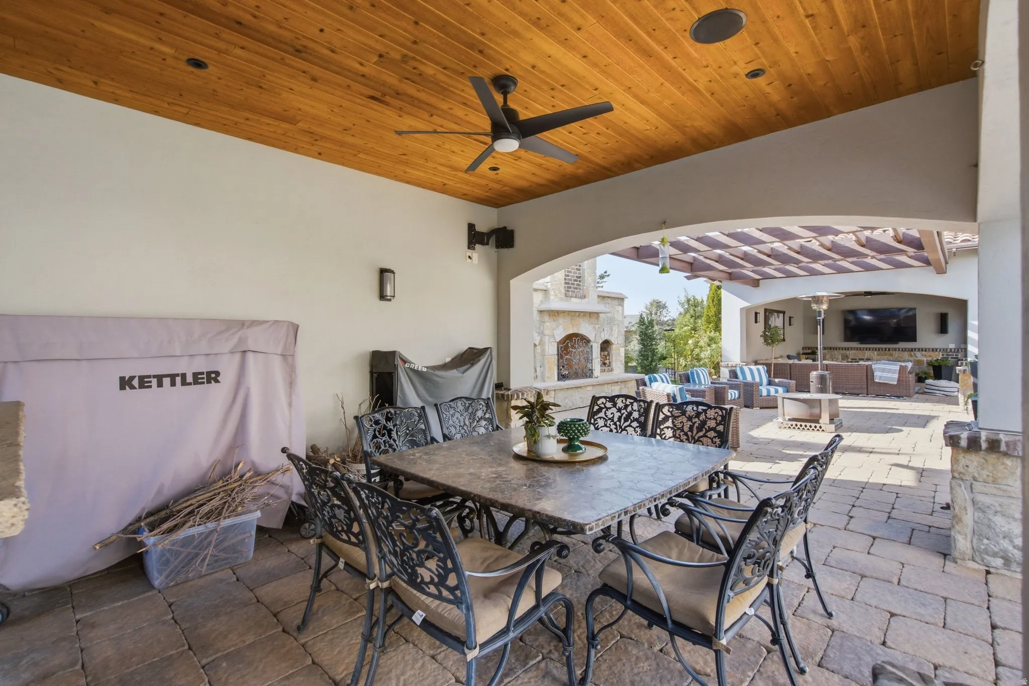 Covered patio featuring a wood-panel ceiling, ceiling fan, recessed lighting, and paver flooring
