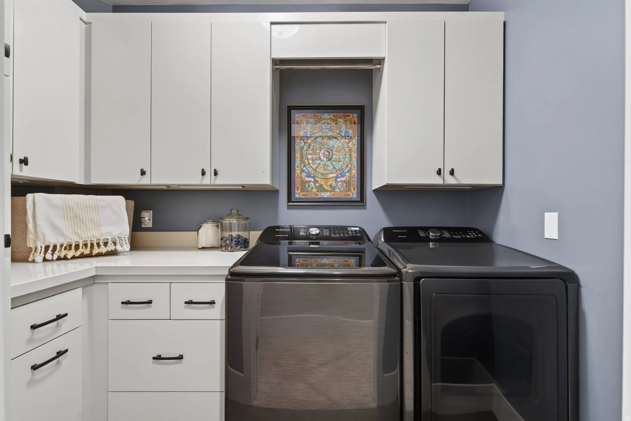 Built-in white cabinetry, white countertop, and black hardware
