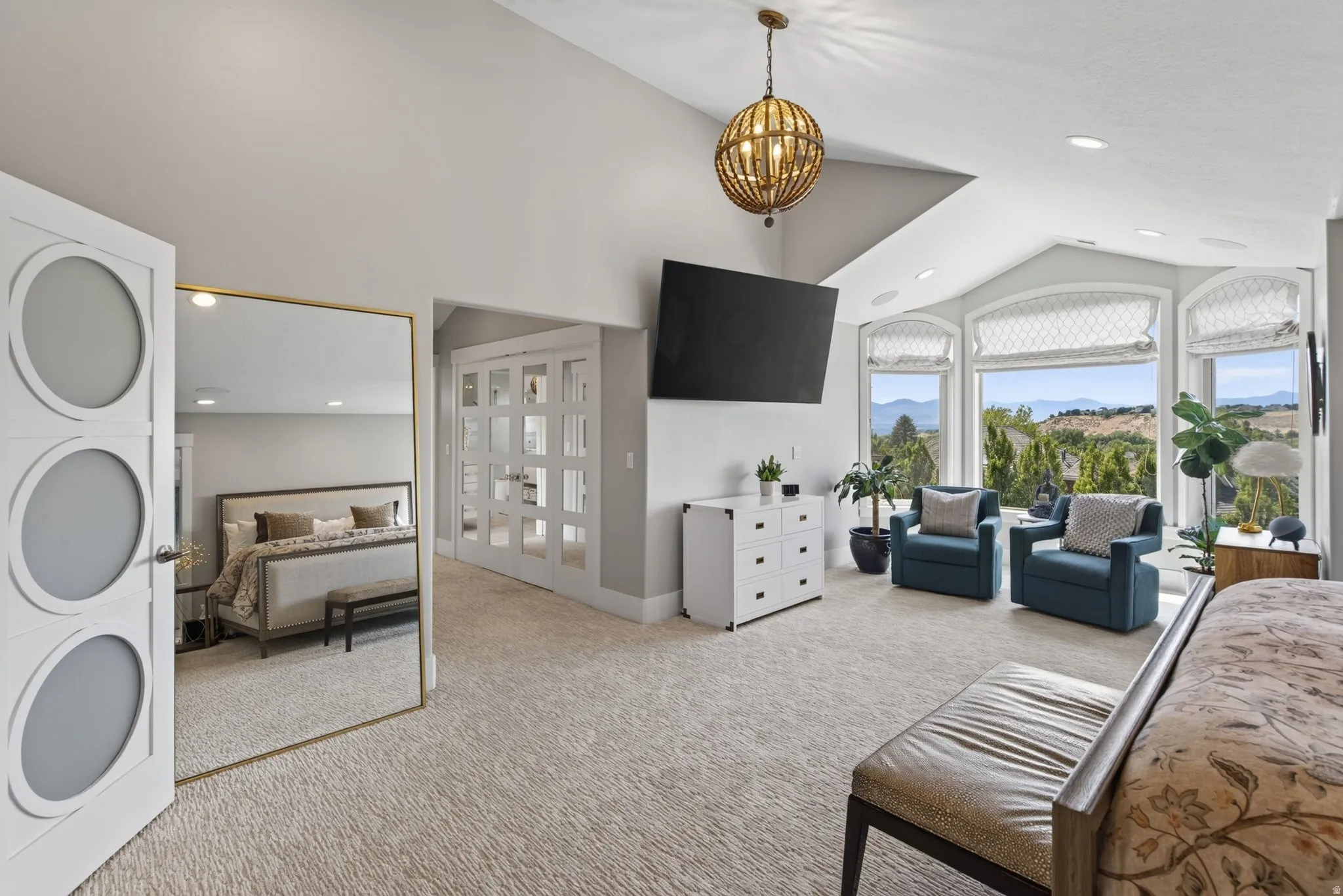 Vaulted ceiling with a spherical chandelier, expansive windows, recessed lighting, and light-toned carpeting