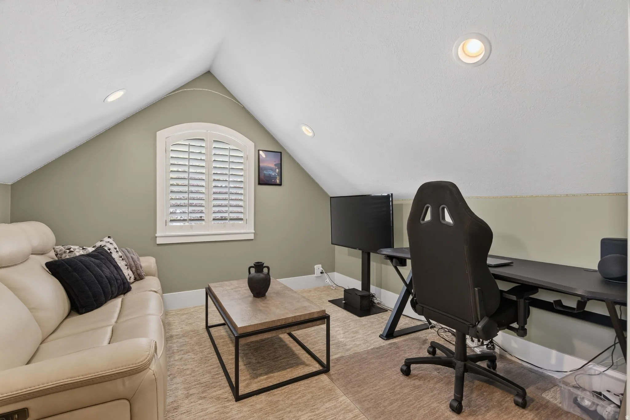Recessed lighting, arched window with plantation shutters, wood-finish flooring, light-colored walls, and sloped ceiling