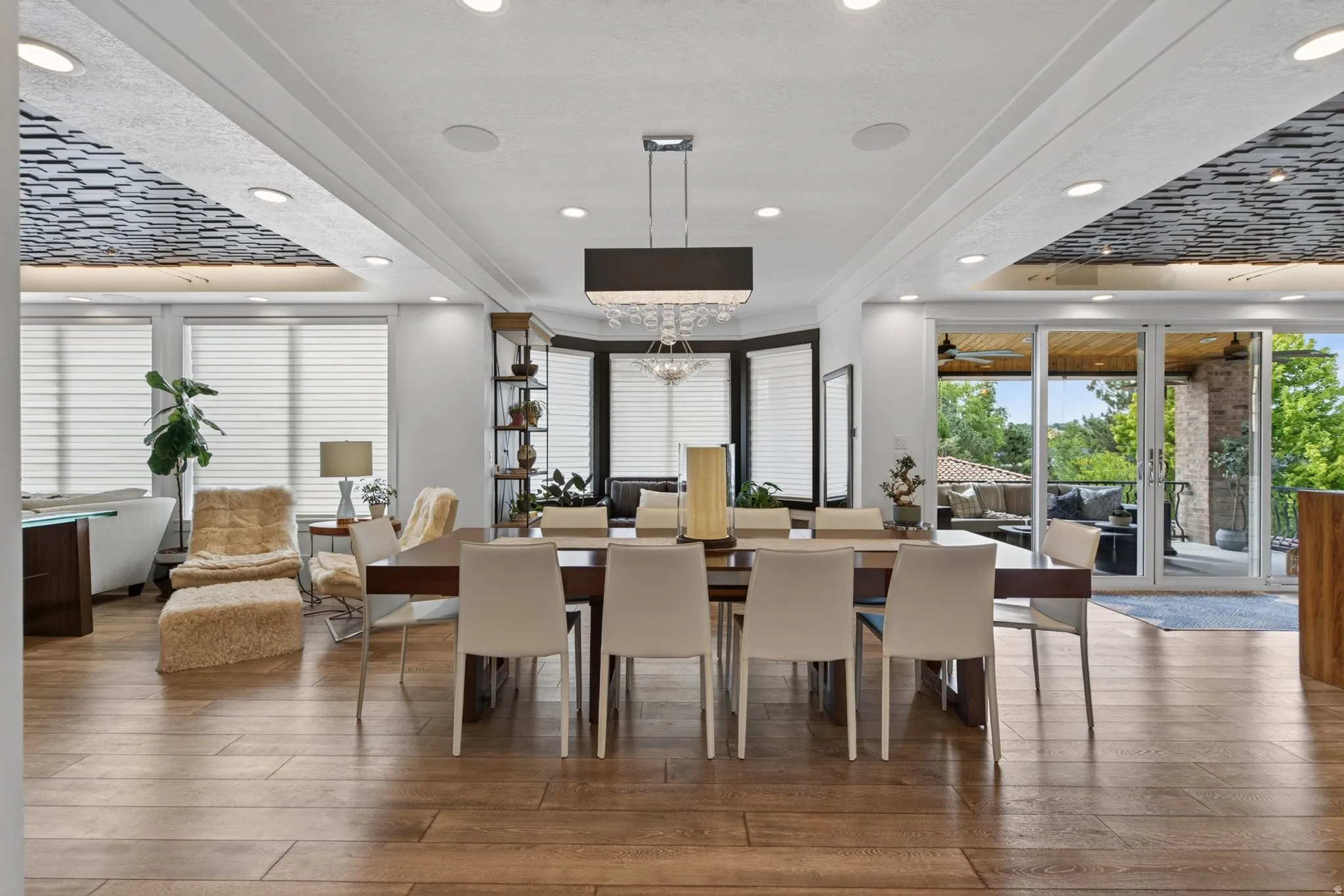 Wood-finish flooring, recessed lighting, decorative ceiling panels, sliding glass doors, and a built-in shelving unit
