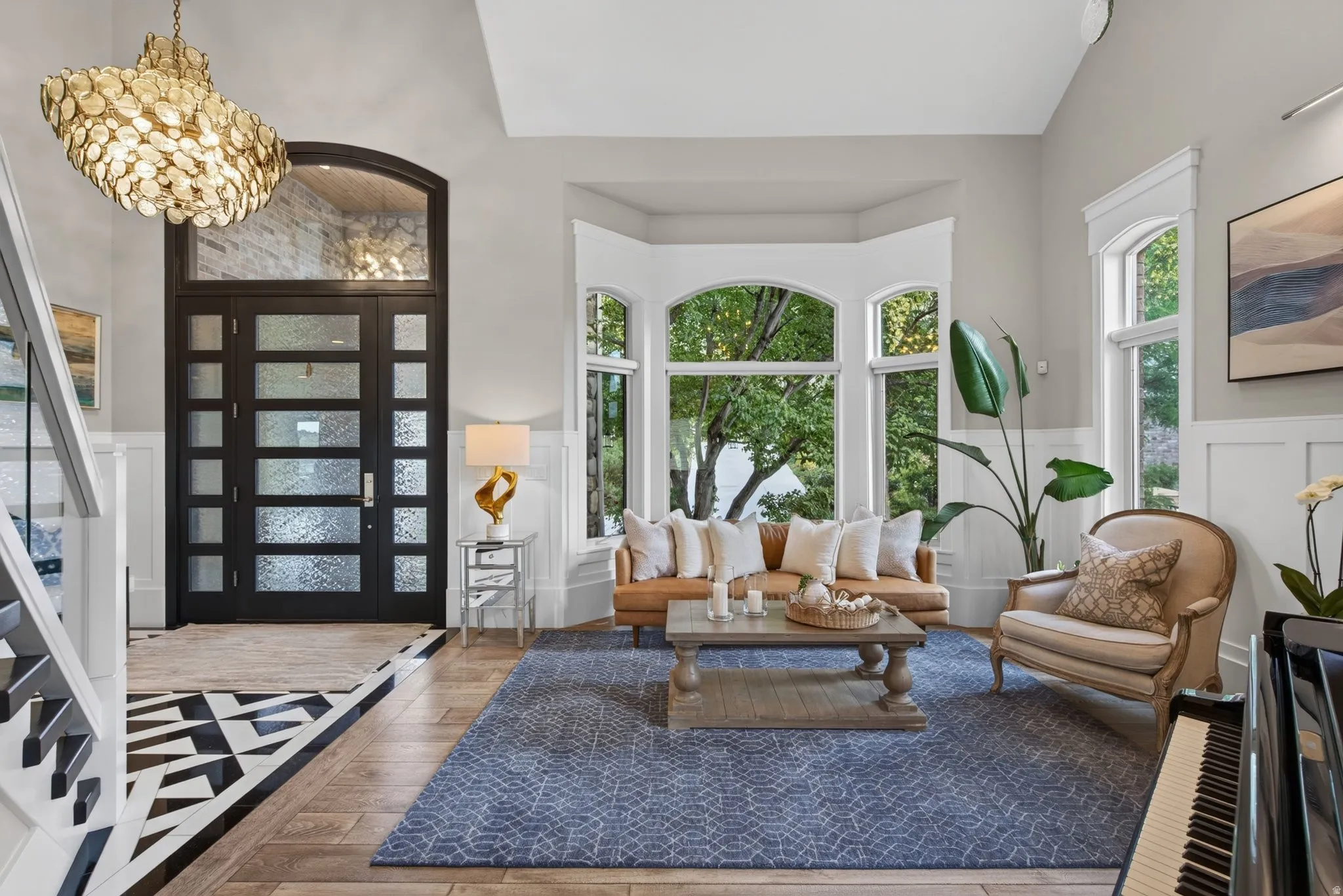 Two-story foyer featuring an arched transom window above a multi-panel door with textured glass
