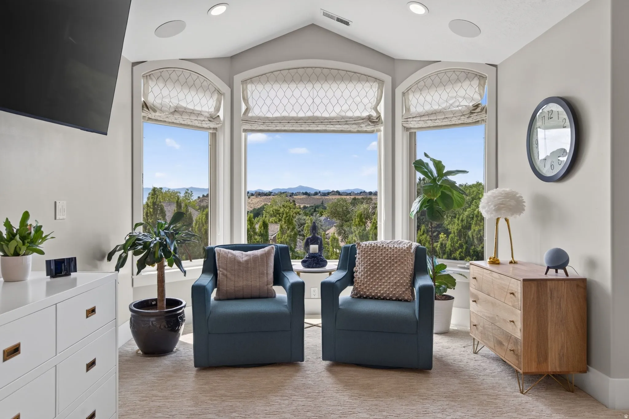 Bay window with three arched windows, recessed lighting, and patterned window treatments