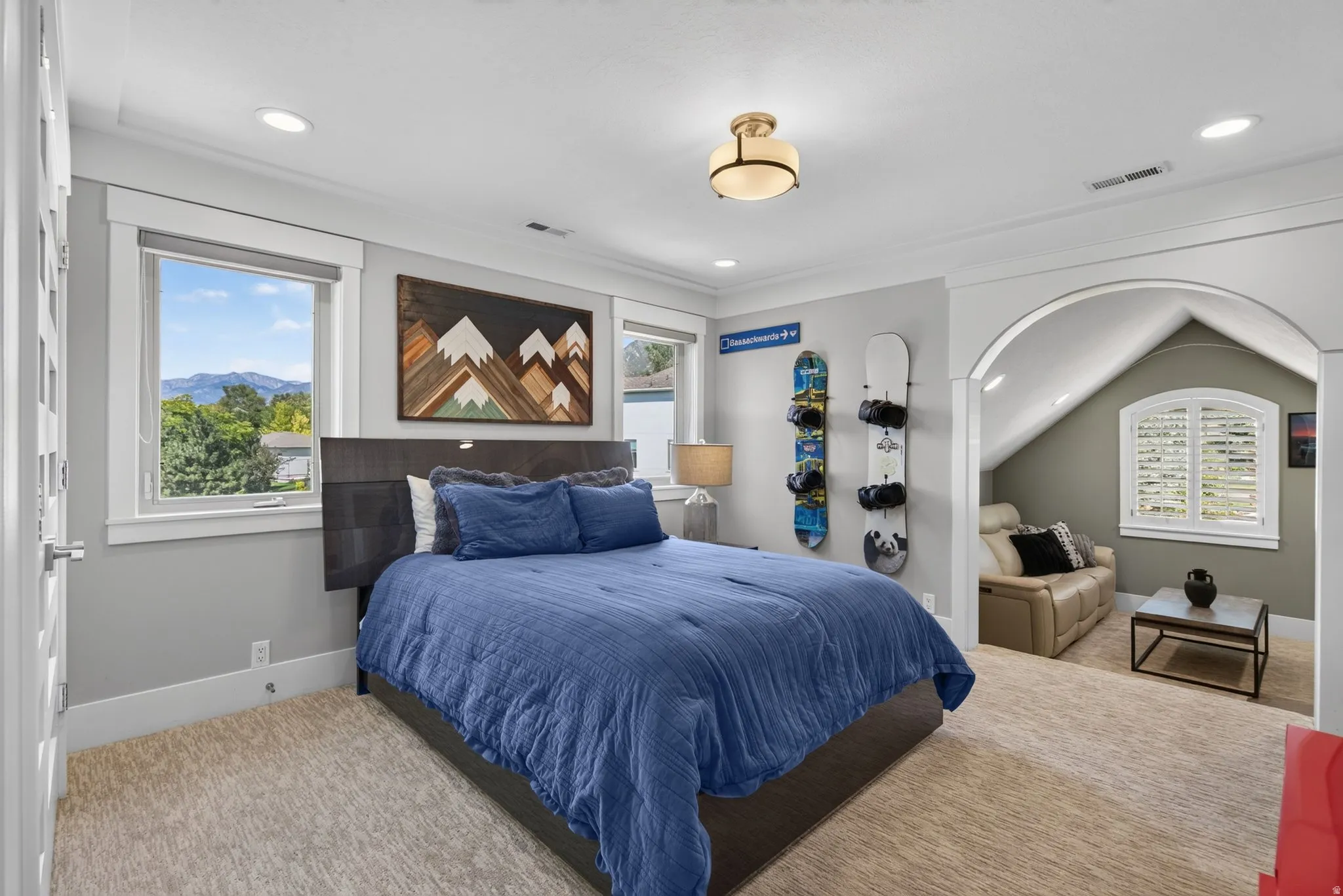 Recessed lighting, arched entryway, window with mountain backdrop, ceiling-mounted light fixture, white trim details
