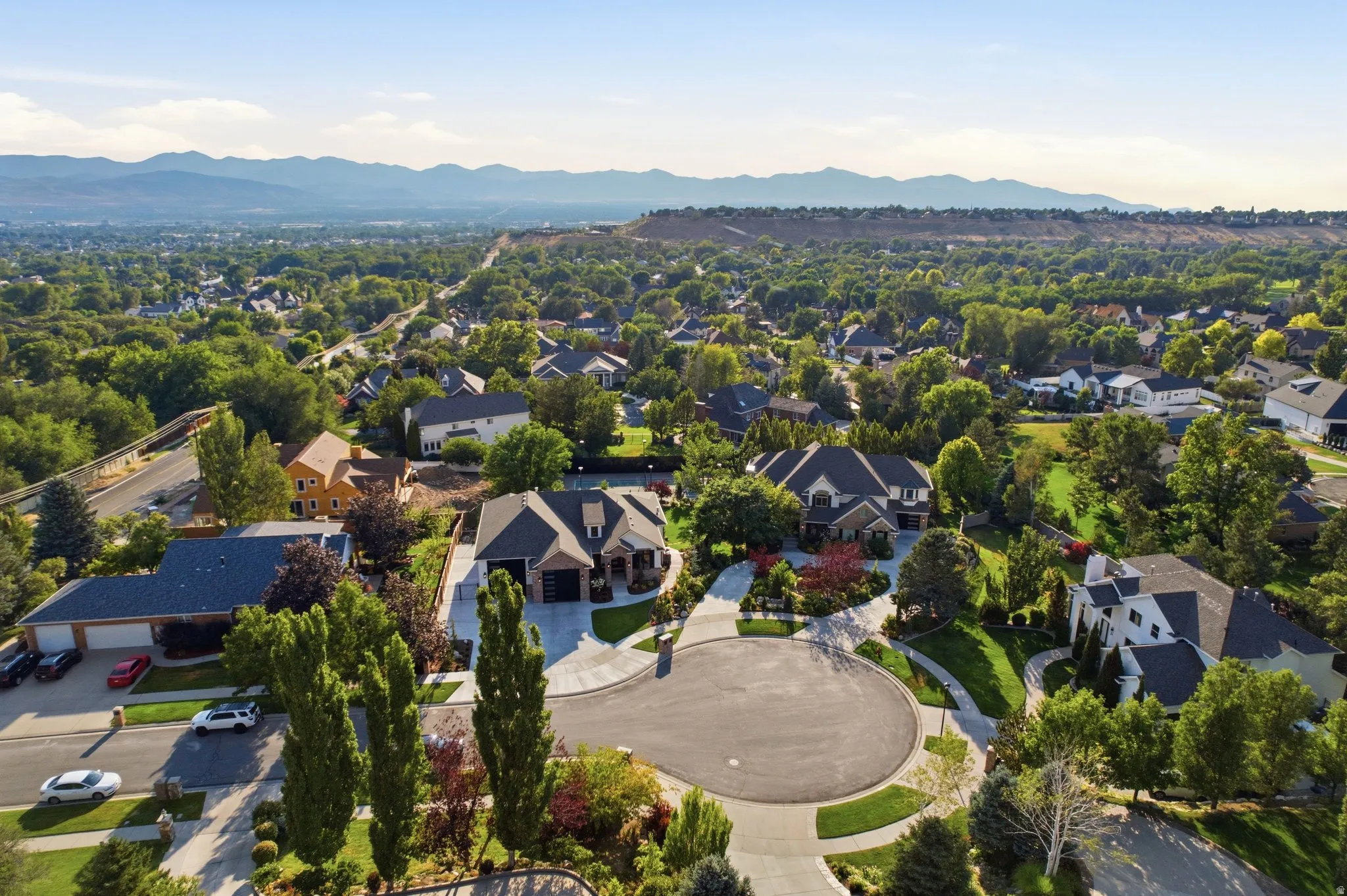 Cul-de-sac location with mature trees, established landscaping, and mountain backdrop