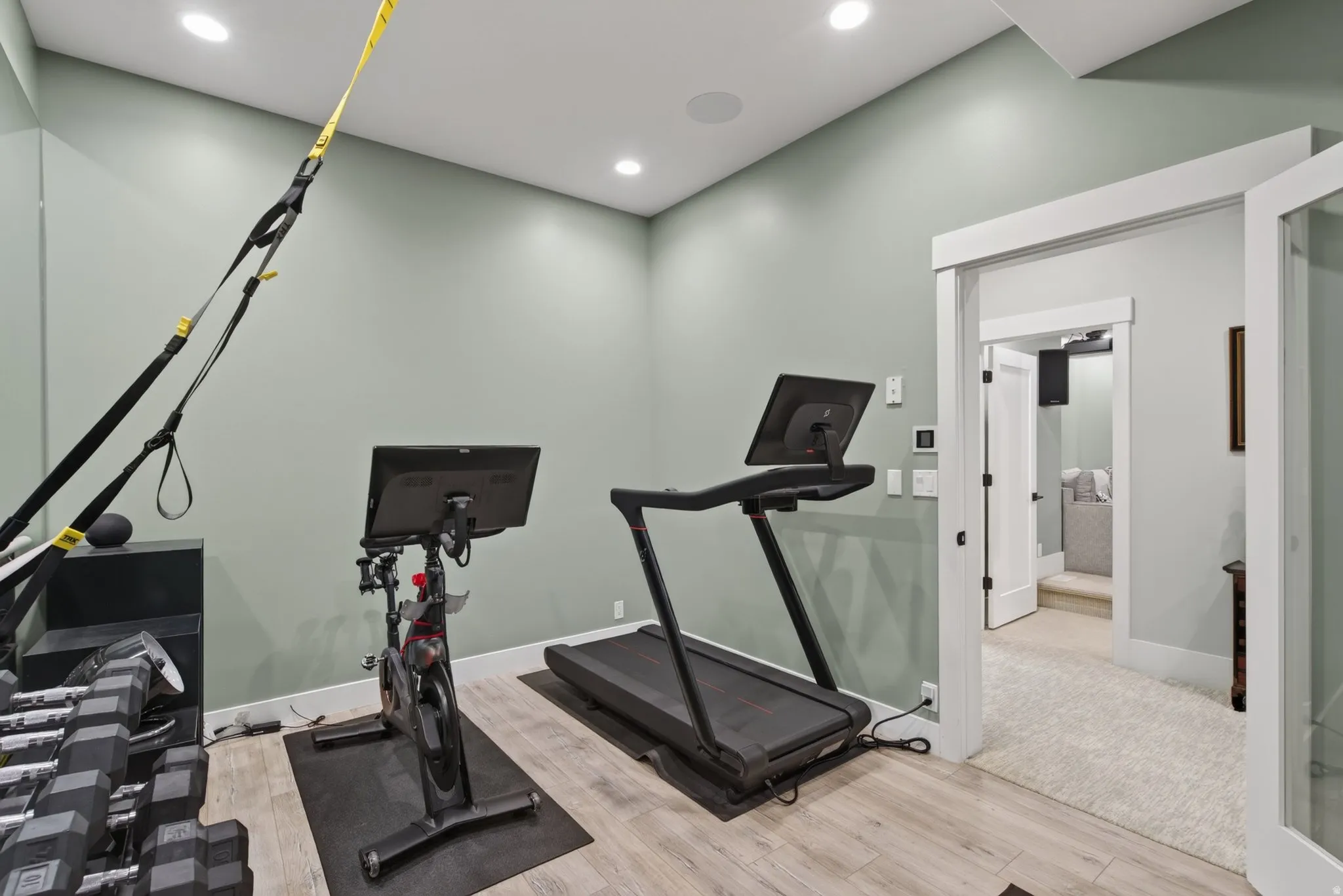 Recessed lighting illuminates the room with wood-finish flooring