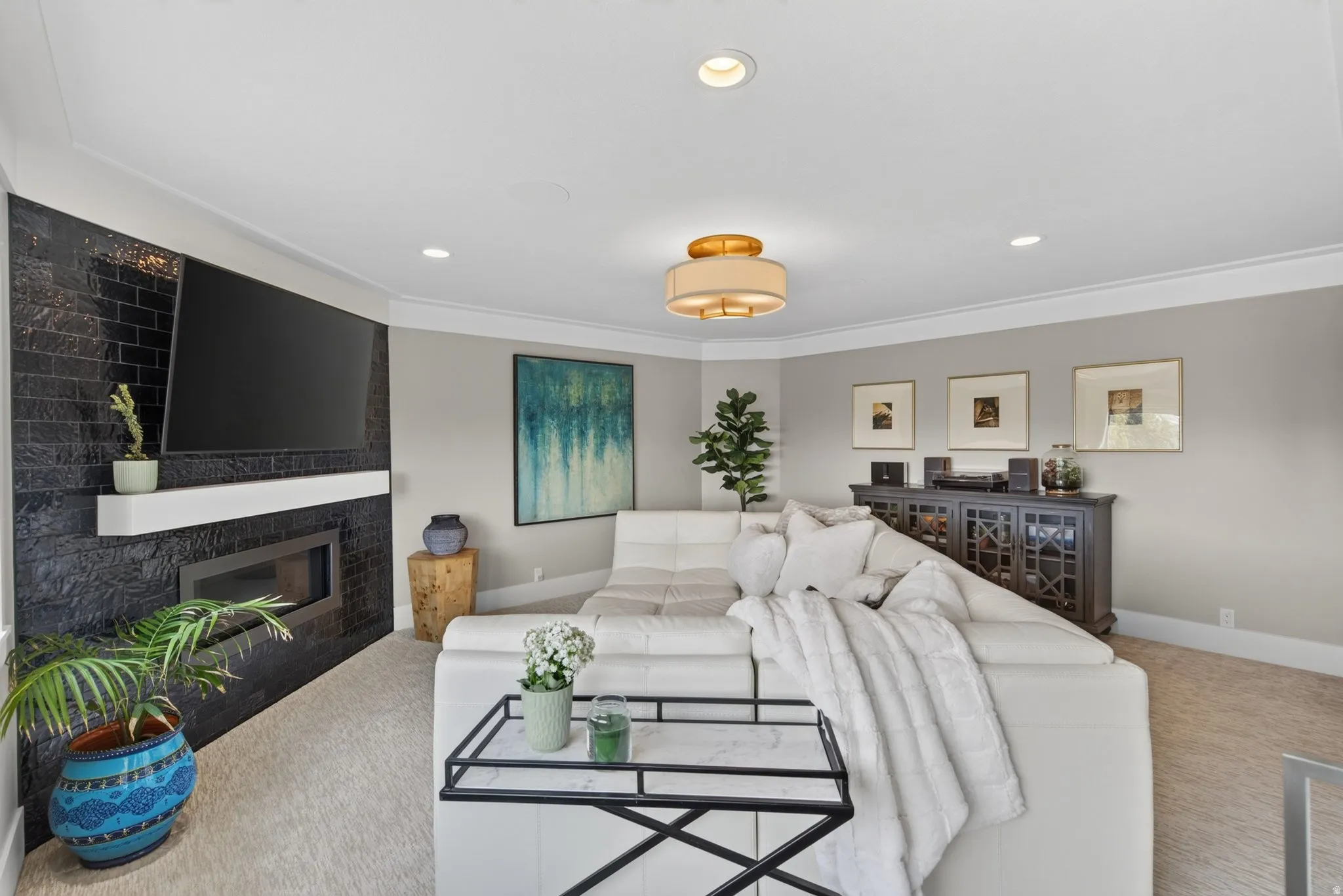 Recessed lighting, crown molding, and a modern ceiling fixture illuminate the space