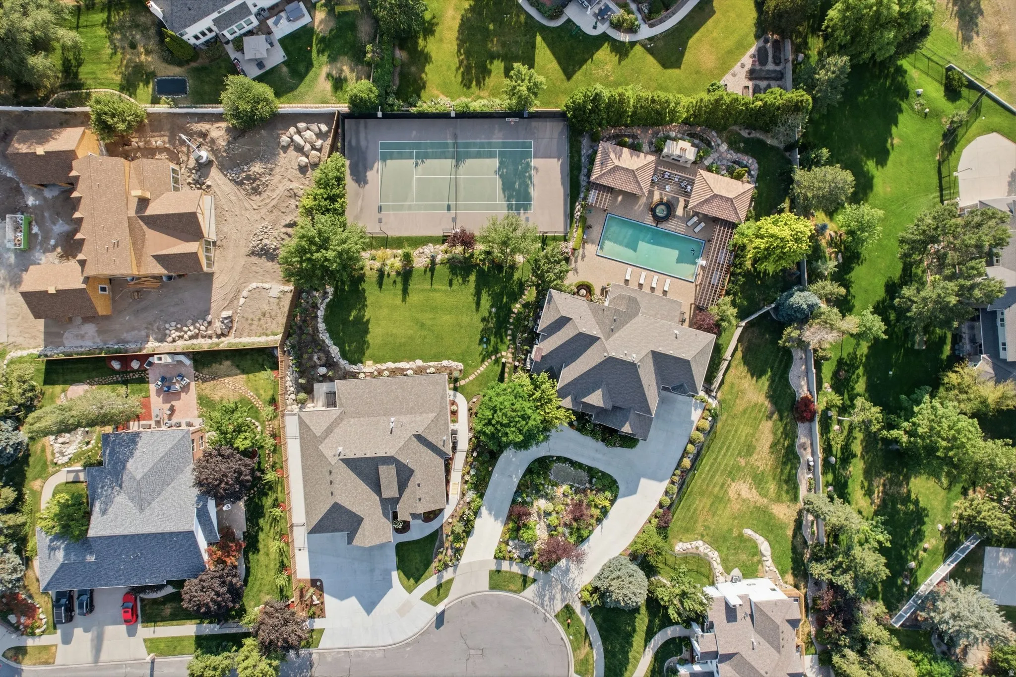 Expansive property featuring a tennis court, swimming pool, and multiple structures