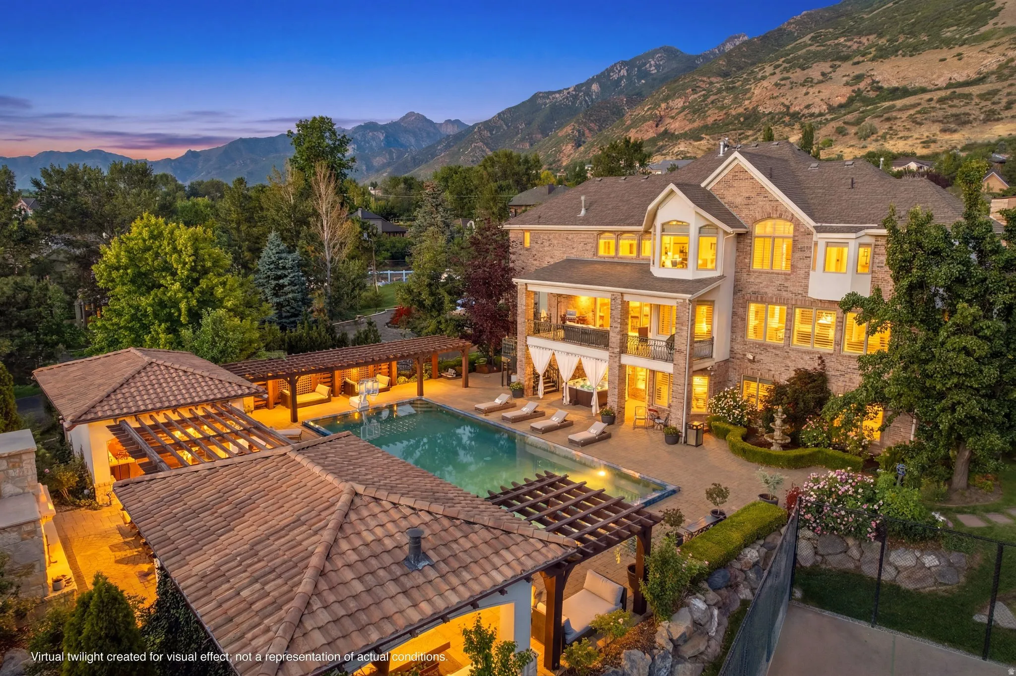 Brick exterior residence with multiple balconies, a swimming pool, and an adjacent pergola-covered lounge area