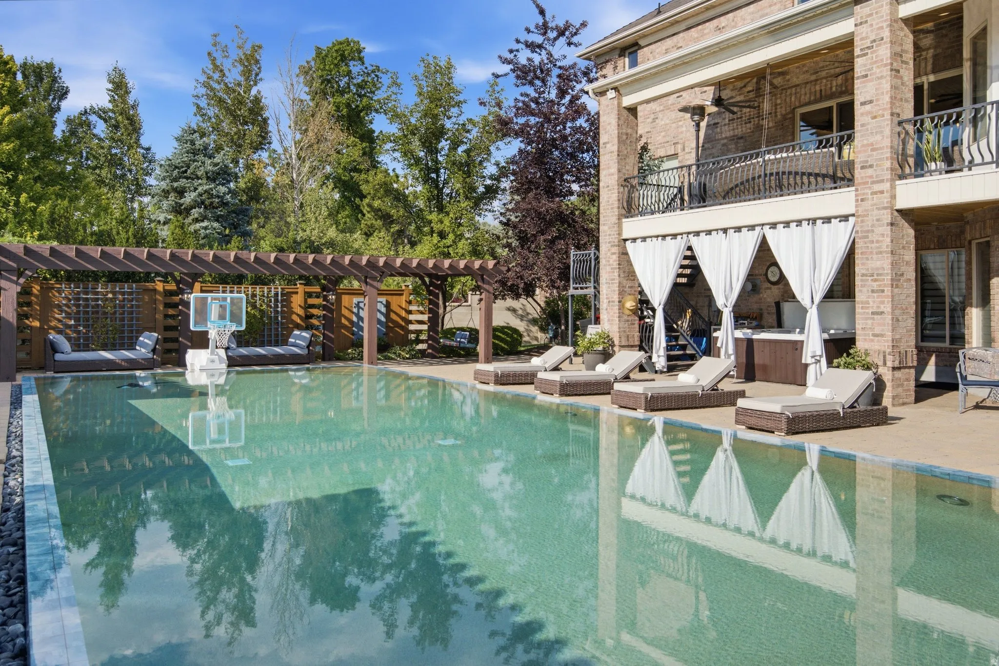 Outdoor swimming pool with integrated spa and surrounding paver patio