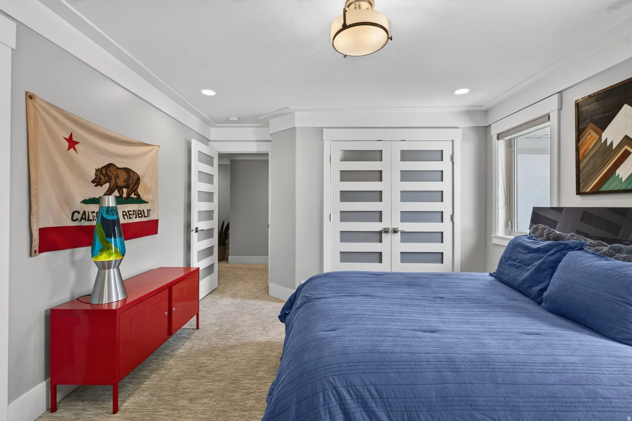 Recessed lighting, crown molding, double doors with frosted glass panels, and a window with roller shade