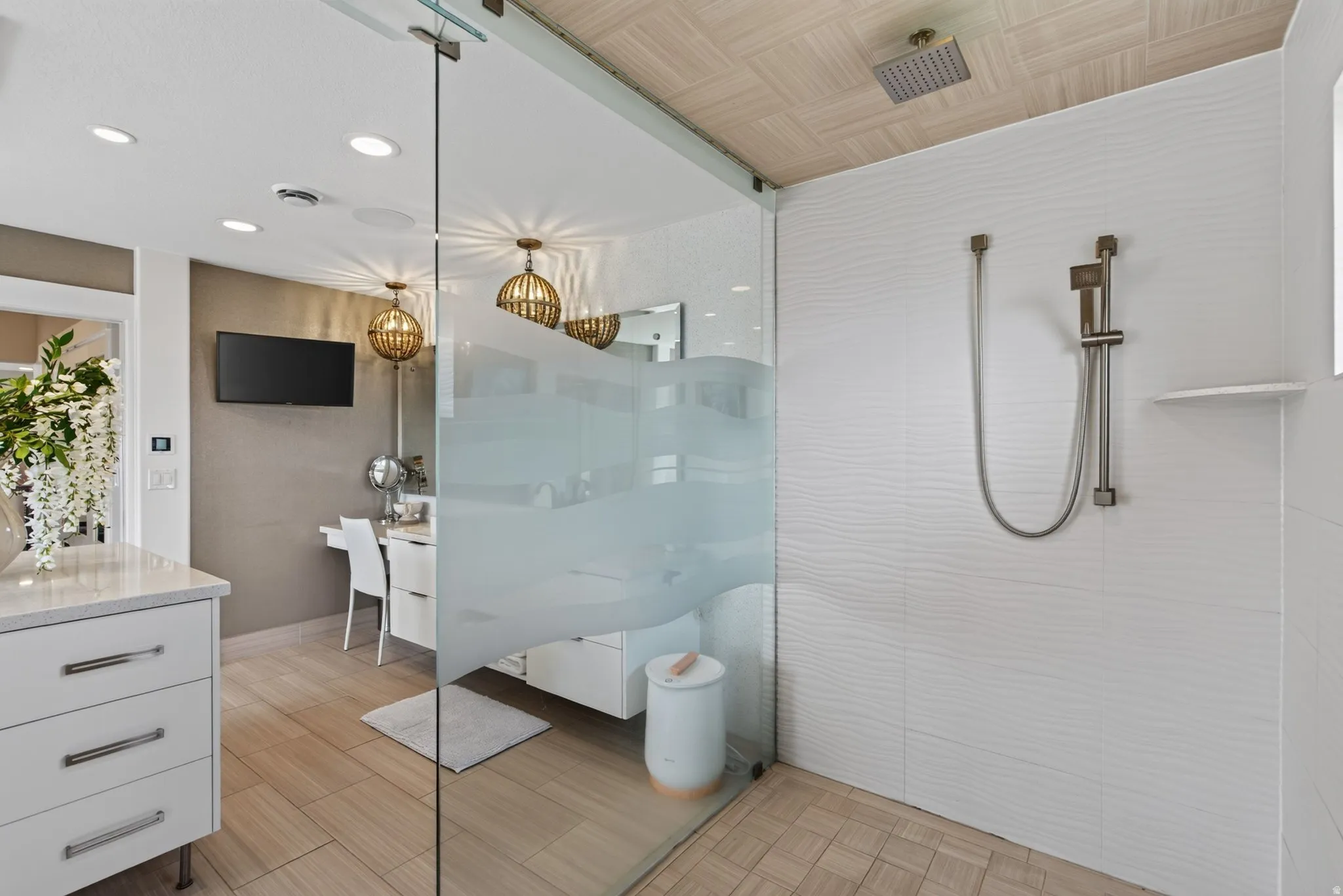 Glass-enclosed shower with a rainfall showerhead and handheld sprayer