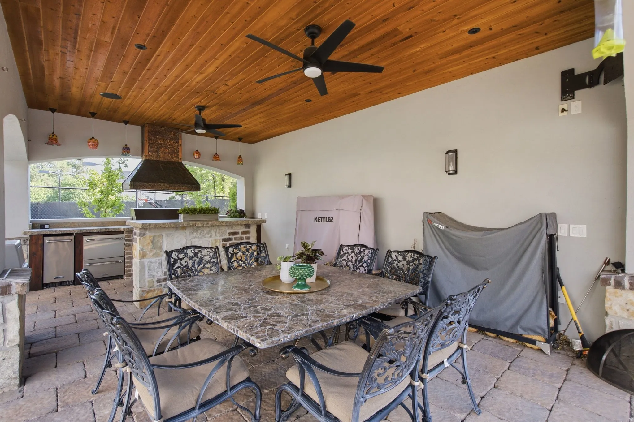 Covered outdoor living space featuring a wood-panel ceiling, recessed lighting, and dual ceiling fans