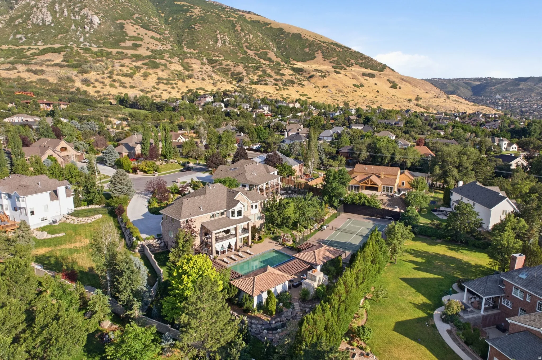 Expansive property featuring a multi-level residence, private tennis court, and an in-ground swimming pool