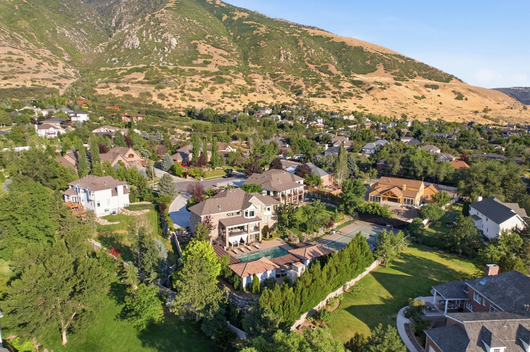 Expansive property featuring a multi-level residence, swimming pool, and private tennis court