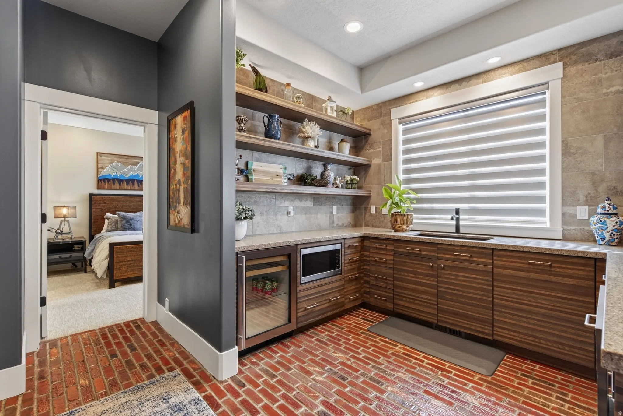 Brick flooring with a built-in wet bar featuring wood-finish cabinetry, a beverage refrigerator, and a microwave