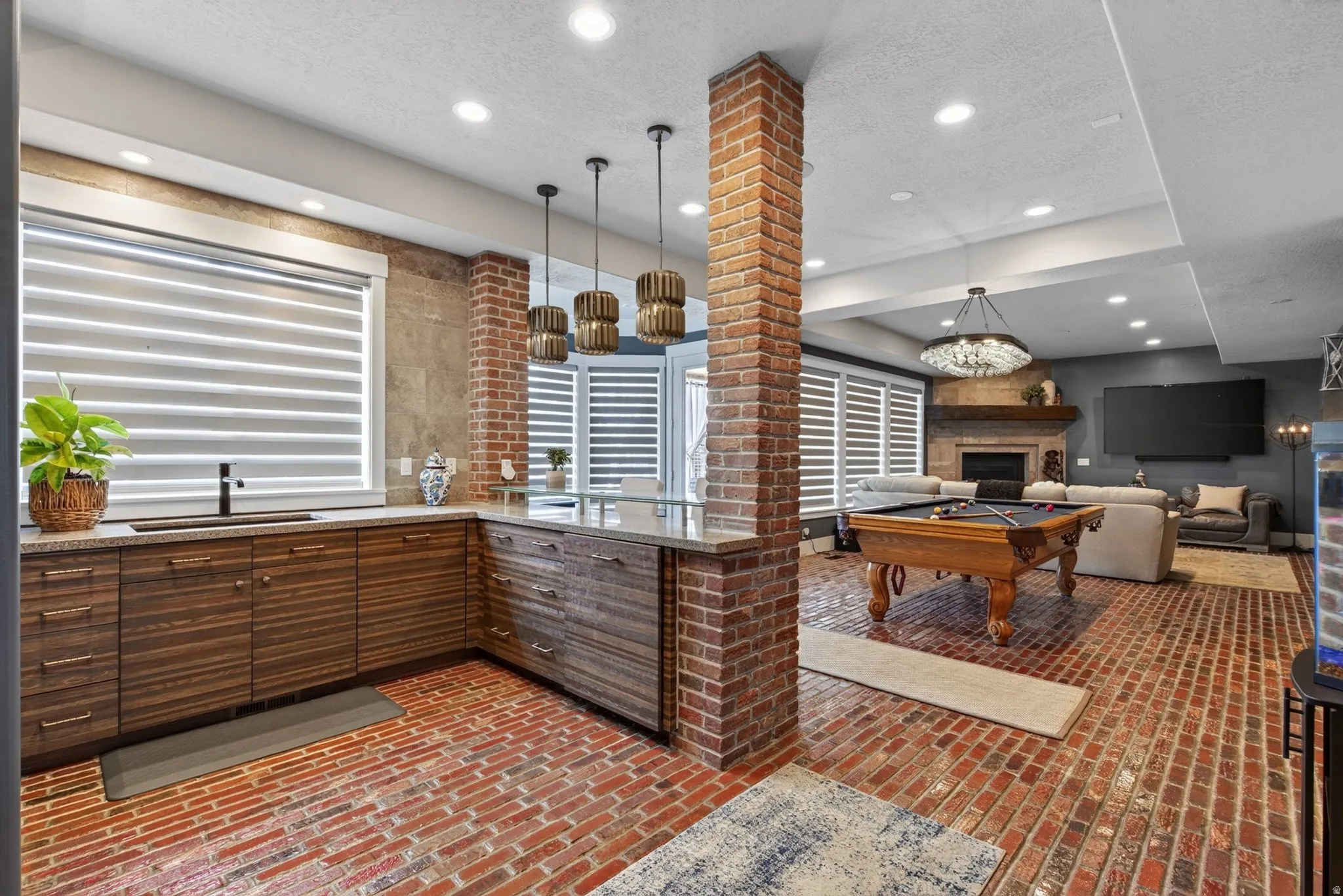 Brick flooring, exposed brick structural elements, wood-finish cabinetry, built-in sink, and recessed lighting